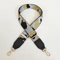 Macro detail of camo embroidered handbag strap with black leather ends and gold buckle - Light Blue Gold Camouflage