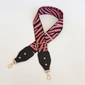 Dettaglio della tracolla zebrata rosa con fibbia dorata regolabile e punte in pelle - Stampa Zebra (108) / Rosa con pelle nera e gancio dorato