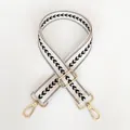 Detail view of off-white jacquard wide shoulder strap with black chevron patterns and gold hooks - Cream White + Gold Hook