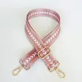 Close-up of pink nylon bag strap with white V-pattern and gold metal hardware hooks - Pink + Gold Hook