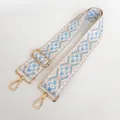 Close-up of ethnic style woven strap in sky blue and cream with gold metal swivel hooks - US 3