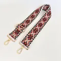 Detail of red and black ethnic woven bag strap with golden metal hooks and adjustable buckle - US 8