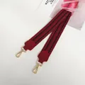 Macro shot of burgundy wide canvas bag strap with gold metal hooks and geometric patterns - Wine Red + Gold Hook