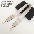Detail of cream white nylon bag strap with gold hooks and leather trim on a black book - Gunmetal Hook / Rice White