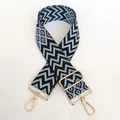 Detail of blue geometric woven nylon bag strap with polished gold swivel snap hooks - Black Base Light Blue + Gold Hook