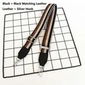 Close-up of adjustable striped handbag strap with leather ends and silver metal hooks - Black With Black Leather Trim And Silver Hook