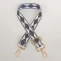 Detailsicht des weißen Gurtes mit schwarzem Muster und goldenen Karabinerhaken - Weiß + Goldener Haken