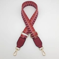 Close-up of red and pink jacquard woven strap with golden metal hardware and leather ends - Silver Hook / Red Brown Pink / Wine Red Leather