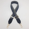 Detail showing the adjustable geometric woven shoulder strap with gold metal lobster clasps - Silver Hook / Dark Grey Blue / Black Leather