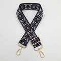 Detail of bohemian purple embroidered bag strap with golden metal hardware and floral pattern - Black Background Purple Edge White
