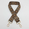 Detail of ethnic embroidery bag strap with golden metal adjusters and lobster clasps - Coffee Background Brown Edge Beige