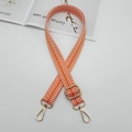 Close-up of orange and white zigzag canvas strap with adjustable gold metal carabiners - Orange And White With Gold Hook