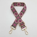 Close-up of ethnic embroidered bag strap with gold lobster clasps and adjustable buckle - Beige Background Rose Red Black