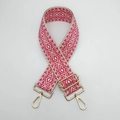 Macro shot of geometric weave purse strap with gold metal hooks and adjustable buckle - Beige Rose Red Gold Hook