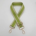 Détail macro d'une bandoulière tissée chevron vert et blanc avec mousquetons dorés - Crochet en Métal Doré / Vert Fluorescent