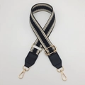 Gros plan sur la bandoulière tissée à chevrons avec crochets dorés et embouts en cuir - Quincaillerie Argentée / Noir