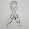 Detail of adjustable white and gold geometric woven strap with golden swivel snap hooks - White with Apricot Edge