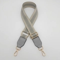 Detail of adjustable grey herringbone bag strap with golden metal hardware and leather ends - Gray