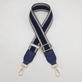 Detail of adjustable geometric navy blue and beige woven strap with gold metal hooks - Blue