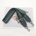Close-up of bohemian geometric woven nylon strap with dark green leather and metal hook - Green Webbing Green Leather + Gunmetal Hook