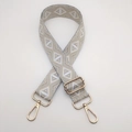 Detail of adjustable geometric ethnic strap with light gold metal swivel hooks and buckles - Grey Silver Thread Diamond + Gold Hook