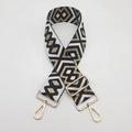 Nahaufnahme der ethnischen Jacquard-Gurtband mit goldenen Metall-Drehhaken - Schwarz und Weiß mit Goldfaden und Goldhaken