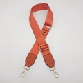 Close-up of orange nylon bag strap featuring gold metal hooks and durable D-ring buckle - Orange