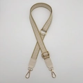 Detail of geometric pattern woven bag strap with adjustable gold metal buckles - Khaki Border Off-white + Off-white Leather