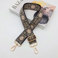 Dettaglio tracolla vintage in jacquard con ganci dorati posata su una rivista - Gancio oro chiaro / Nero con Fiocco Rosa