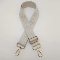 Détail d'une bandoulière beige tissée avec mousqueton doré réglable en métal poli - Blanc Cassé / Crochet Argenté