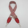 Macro shot of geometric diamond pattern canvas shoulder strap with gold metal buckles - Beige Base Red + Red Leather