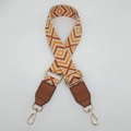 Detail of adjustable wide canvas bag strap with orange diamond jacquard and gold hooks - Beige/Orange Brown Pattern With Brown Leather