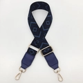 Close-up of diamond pattern canvas strap with blue leather ends and gold metal hooks - Black Base Blue + Blue Leather