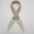 Dettaglio tracolla regolabile in tessuto jacquard con motivo geometrico e ganci dorati - Caffè Crema + Pelle Crema