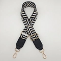 Detailed macro view of geometric diamond woven canvas strap with gold metal lobster clasps - Black Base Off-White + Black Leather