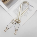 Dettaglio della tracolla regolabile in nylon bianco con motivo a freccia oro e ganci - Hardware Dorato / Bianco