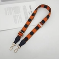 Close-up of adjustable orange and black polka dot wide shoulder strap with gold metal hooks - Orange Black (Black Leather Gold Hook)