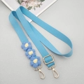 Macro detail of light blue woven crossbody strap with yellow daisy crochet charms - Light Blue With Patch