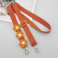 Detail of adjustable orange canvas strap with woven daisy flowers and gold hardware - Orange With Patch