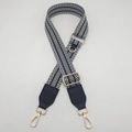 Detail eines verstellbaren schwarz-weißen gewebten Schultergurts mit goldenen Karabinerhaken - Schwarz (Schwarzes Leder) / Hellgold