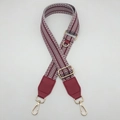 Detail of wide woven canvas bag strap with burgundy patterns and gold metal hardware - White Wine Red (With Wine Red Leather)