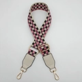 Detail eines verstellbaren Canvas-Gurts mit rosa-schwarzem Schachbrettmuster - Goldener Haken / Beige + Beiges Leder