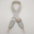 Detail of adjustable beige woven shoulder strap with gold-tone hardware and leather ends - Rice White / Gold
