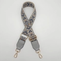 Close-up of ethnic embroidered bag strap with gold metal buckles and leather ends - Gray-Blue/Brown With Gold Hook