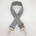 Detail of grey diamond pattern wide woven bag strap with adjustable gold metal hardware - Light Gray