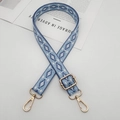 Dettaglio della tracolla ricamata geometrica blu e bianca con moschettoni in metallo oro - Azzurro e Blu Lago / Oro