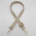 Close-up of geometric woven nylon strap with golden metal lobster clasps and adjusters - Pink Green on Beige