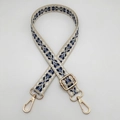 Detail of adjustable nylon bag strap with geometric jacquard pattern and gold metal hooks - Black Blue on Beige
