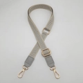 Detailed view of gray maze pattern crossbody bag strap with leather and gold buckle - Grey + Grey Leather