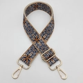 Detail view of ethnic embroidery pattern and adjustable gold metal buckles on wide bag strap - Gold Hook / Beige Brown Blue